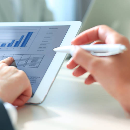 Two people analyzing data on a tablet